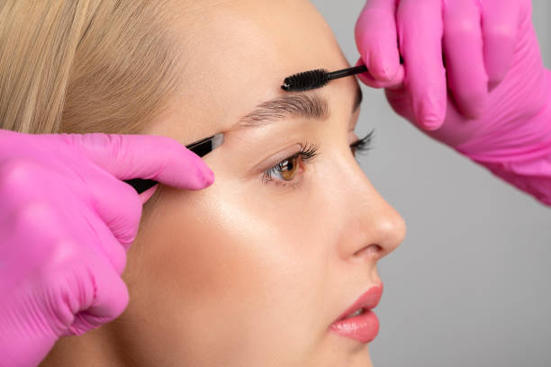 Brown eyeshadow being used to fill in and shape eyebrows for a defined and polished appearance.
