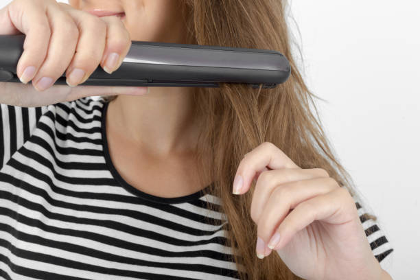 Close-up of foam hair roller being secured to hair for wave styling
